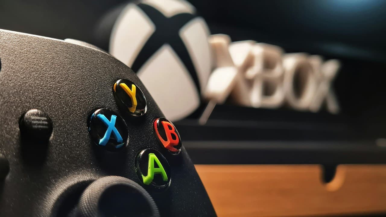 Close-up of an Xbox controller in front of an Xbox console