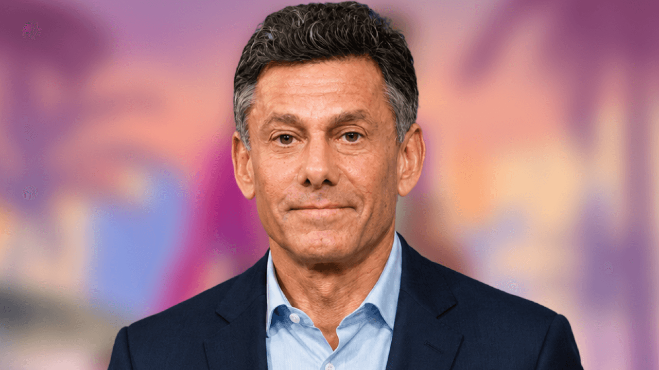 Take-Two CEO Strauss Zelnick portrait against a blurred Grand Theft Auto 6 key-art backdrop