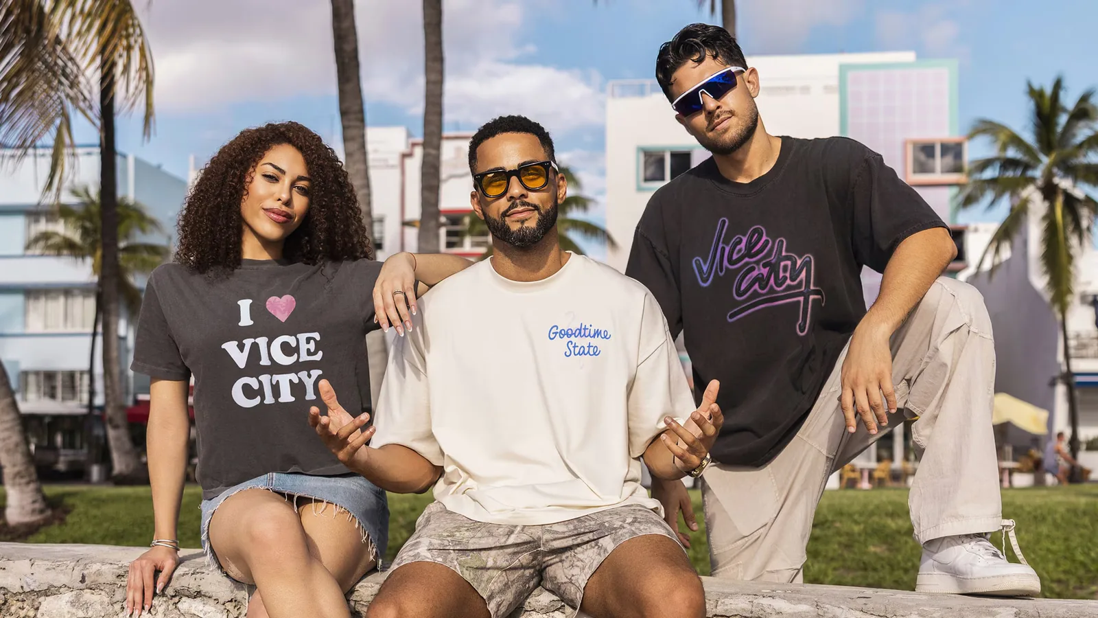 Three models on Ocean Drive wearing the Court Culture Vice City collection: an 'I heart Vice City' tee, a Goodtime State tee and a neon Vice City script tee