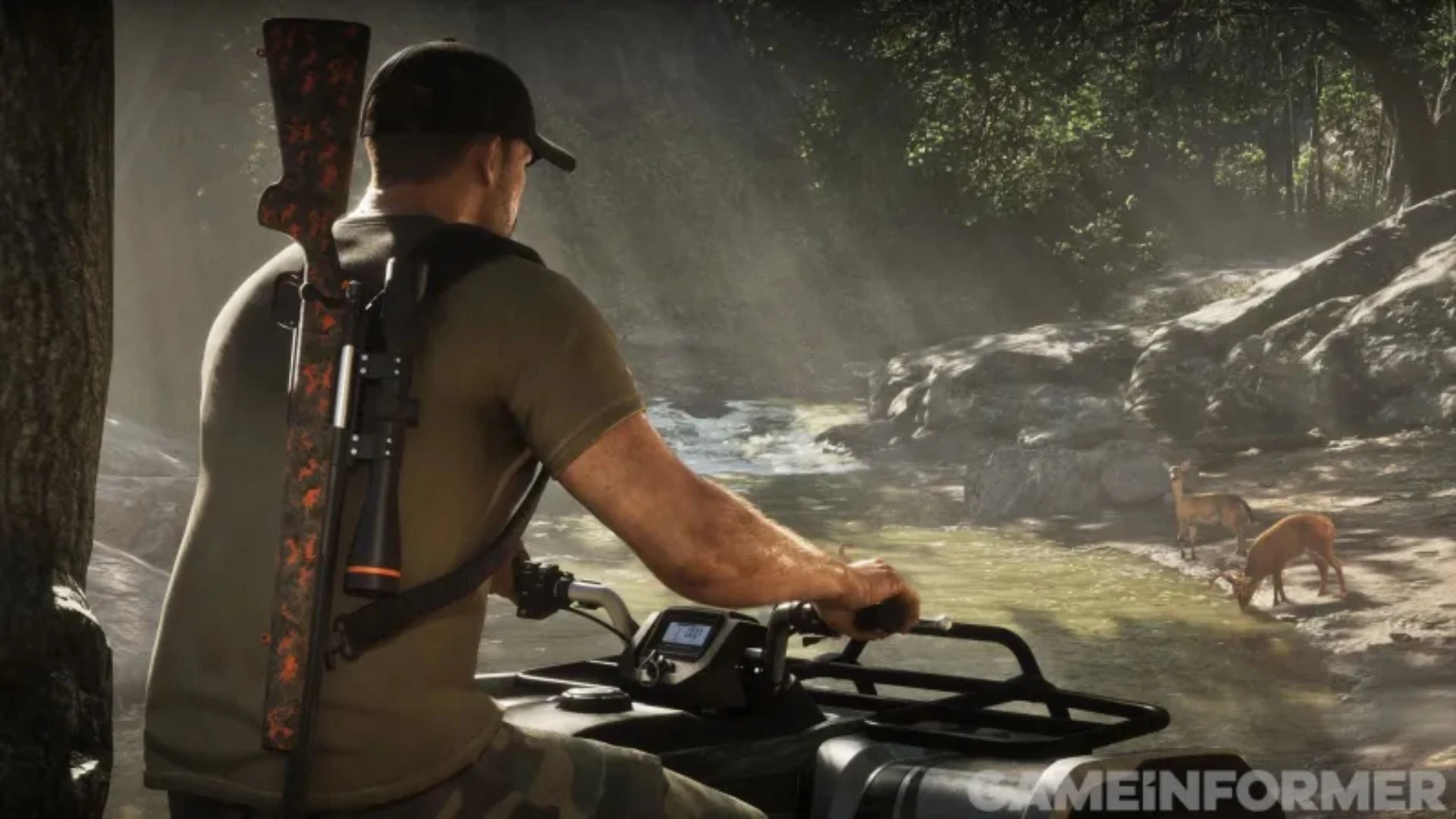 A man with a scoped rifle on his back sits on an ATV watching deer at a forest stream